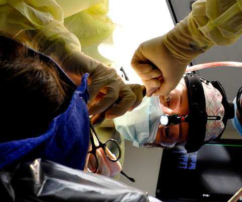 ORAL AND MAXILLOFACIAL SURGEON WORKING ON A PATIENT