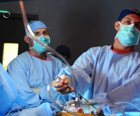 Two surgeons performing procedure on patient 