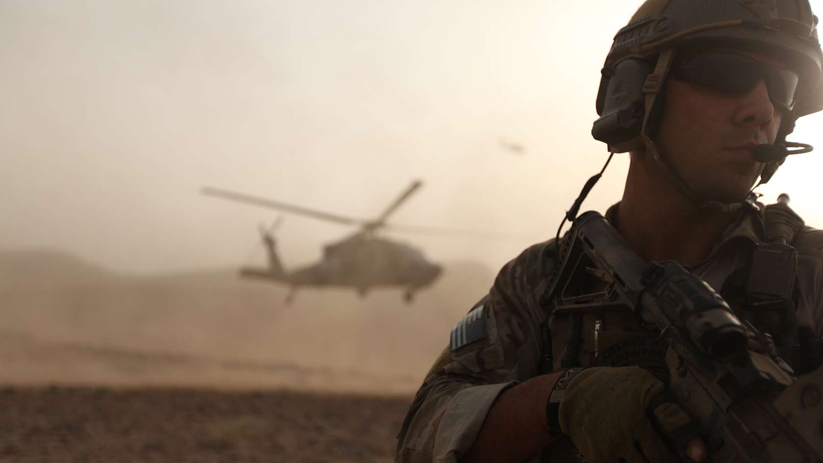 Combat Rescue Officer in desert with helicopter