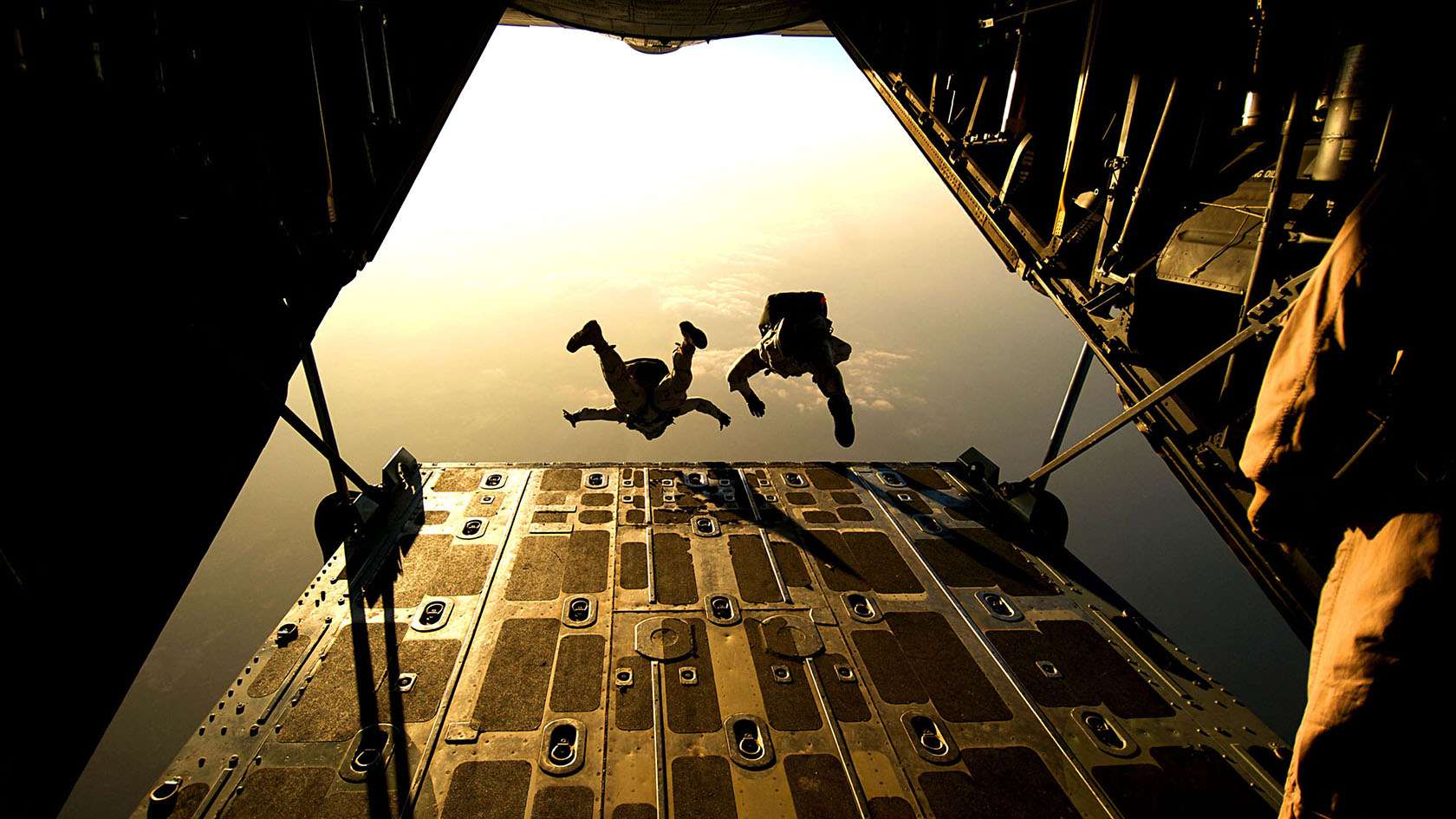 Two pararescue Airmen jumping from plane