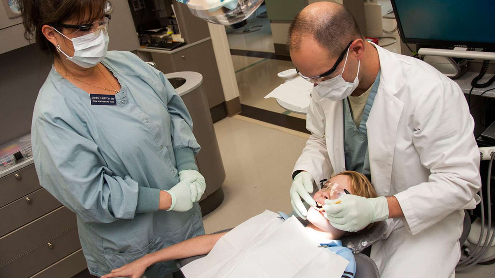 pediatric dentist looking inside a patient's mouth