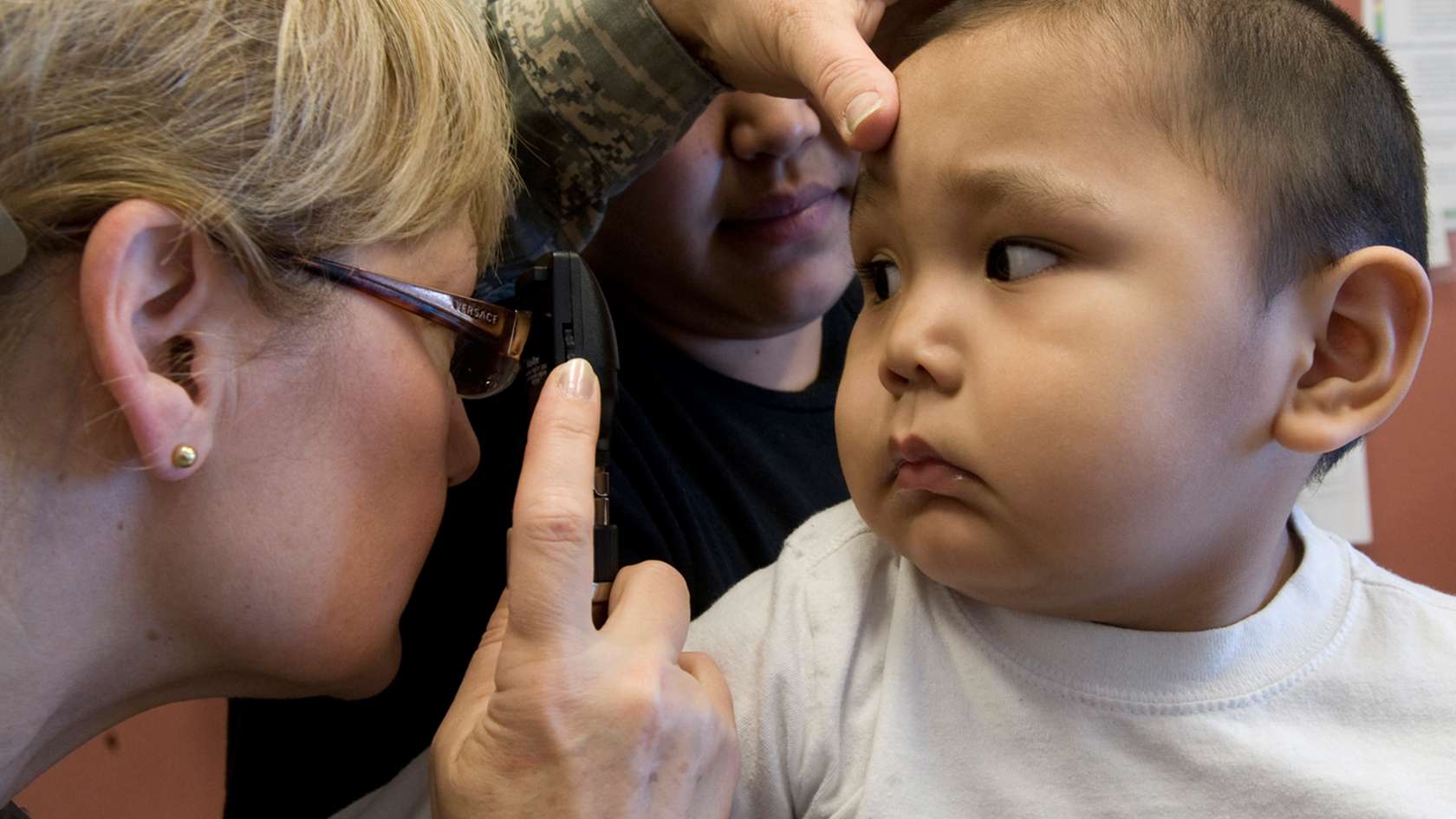 pediatric nurse examining child's eyes