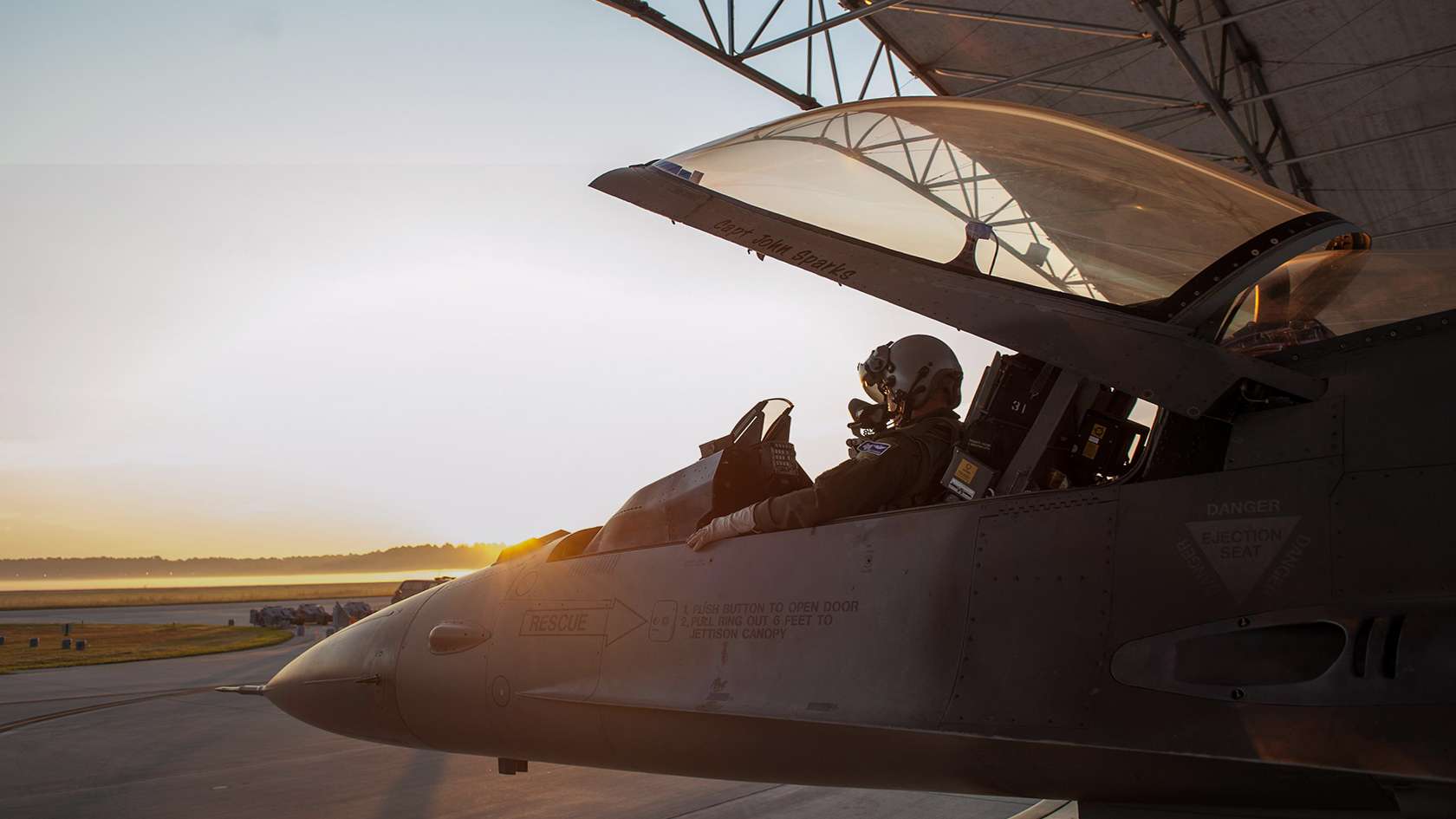 Fighter pilot in cockpit with canopy open