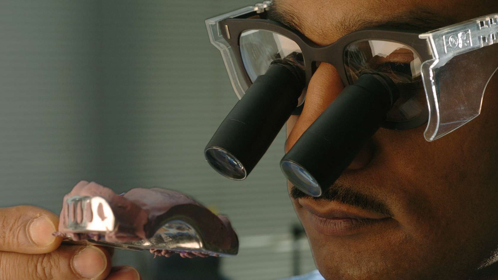 Prosthodontist carefully inspecting 