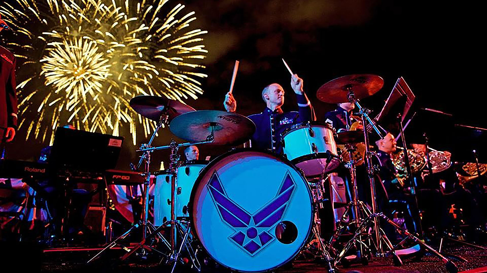 drummer playing with fireworks in background