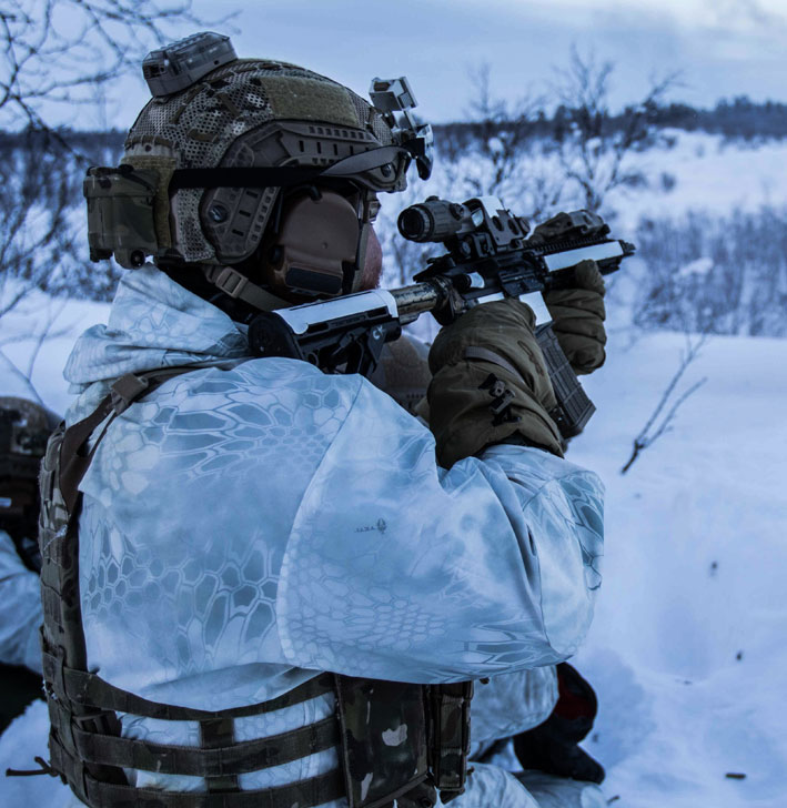 SPECIAL RECONNAISSANCE (SR) pointing his gun to the wilderness in snowy conditions.
