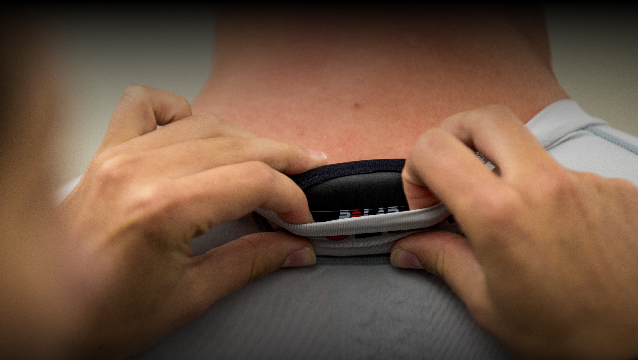 Closeup of hands checking the wearable tech in someone's shirt