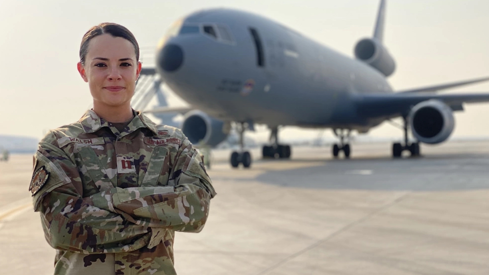 airman standing in front of aircraft