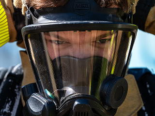 airman firefighter putting on mask