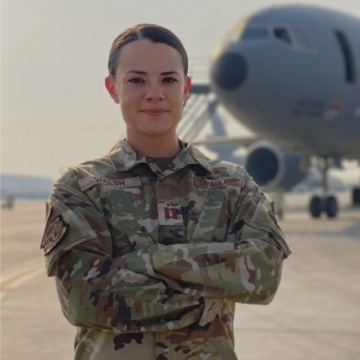 Female Airman posing in front of an aircraft