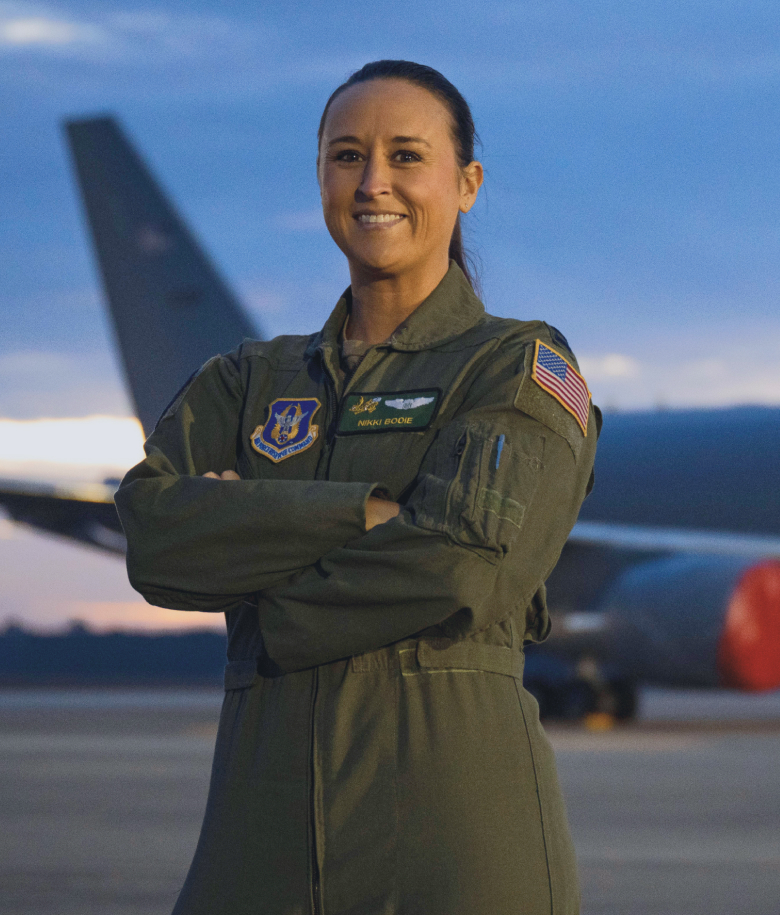 Female Airman posing in front of an aircraft