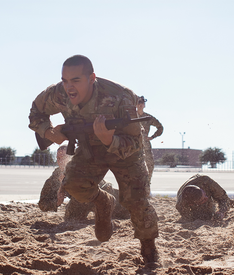 trainee running on sand carrying a weapon