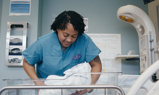 nurse bringing baby back to the crib