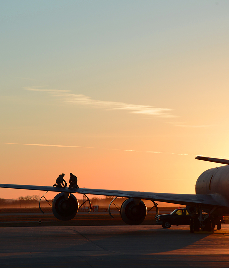 airman on aircraft wing at sunset
