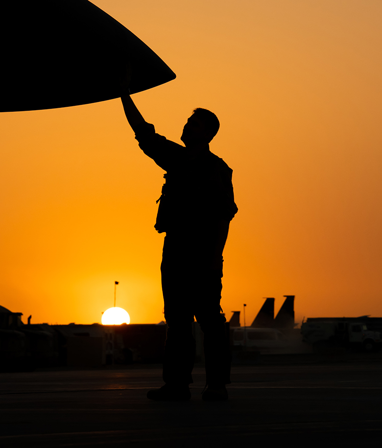 airman and aircraft at sunset