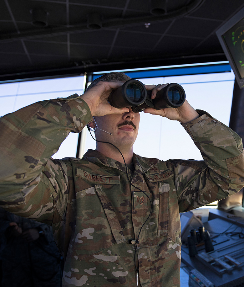 airman gazing out of binoculars