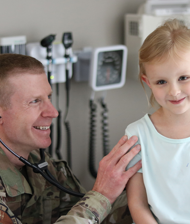 FAMILY NURSE PRACTITIONER engaging with a little girl who is his patient