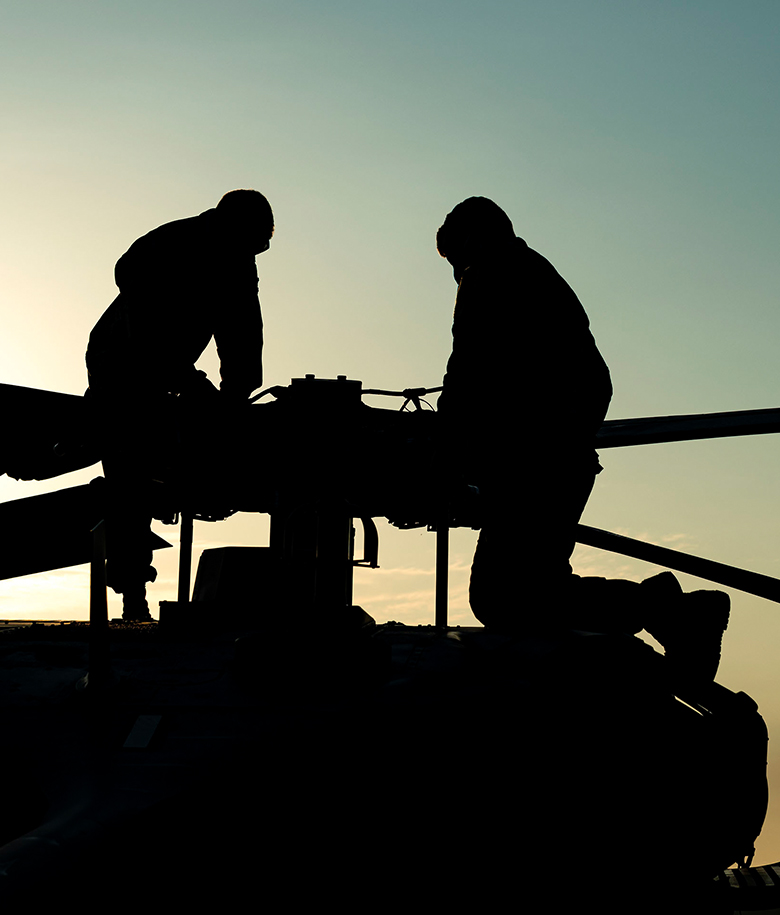 airmen on top of helicopter performing maintenance