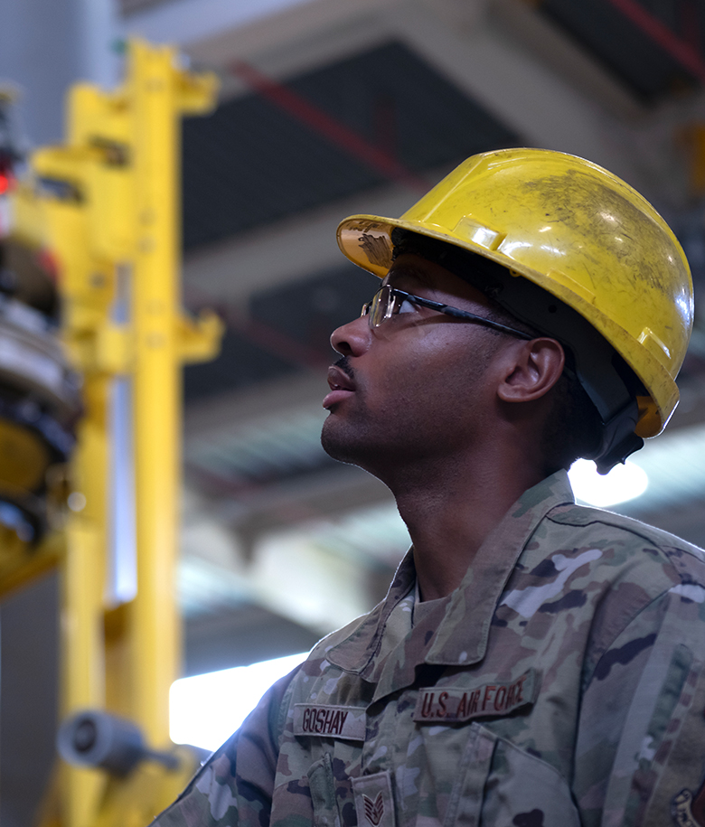 airman wearing yellow hard hat in water plant