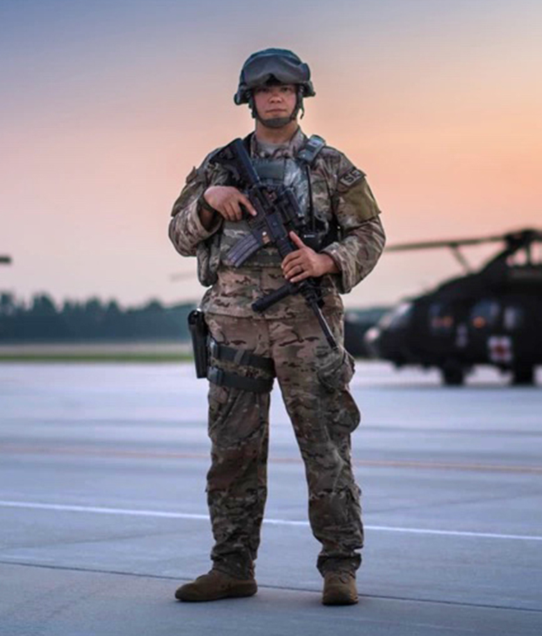 airman standing with a gun looking at the camera