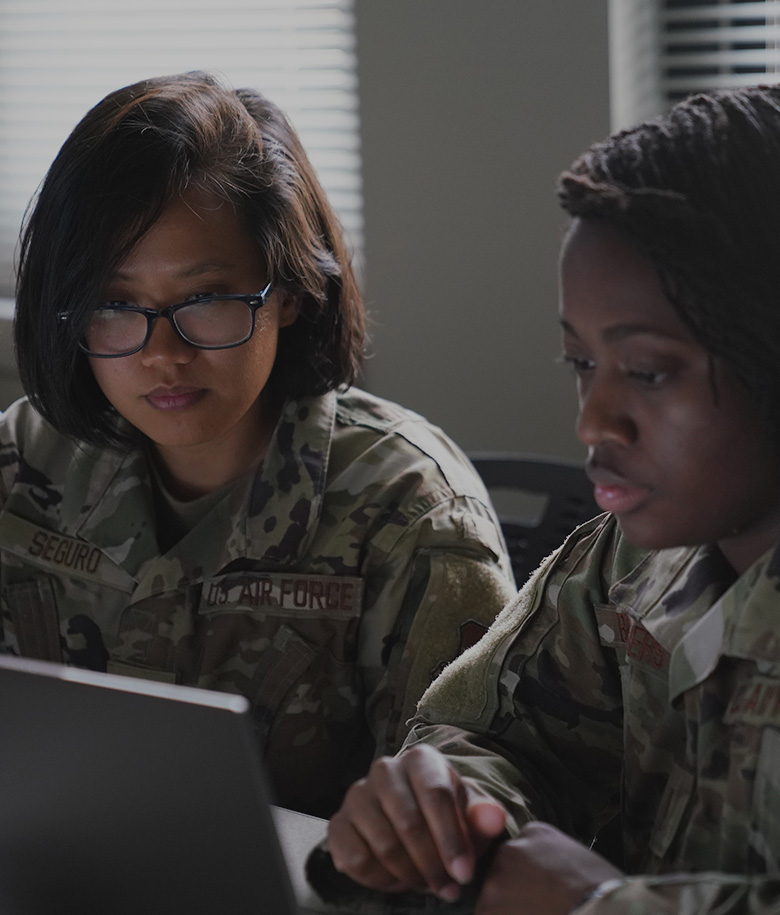 two trainees in front of a laptop studying together