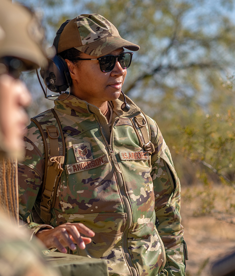 Airman with headphones on paying attention to a person speaking off camera