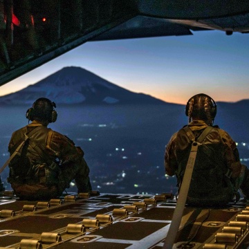 Two airmen overlooking a mountain from aircraft