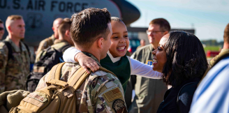 airman holding child with woman