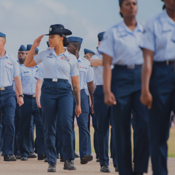 airmen marching and one saluting