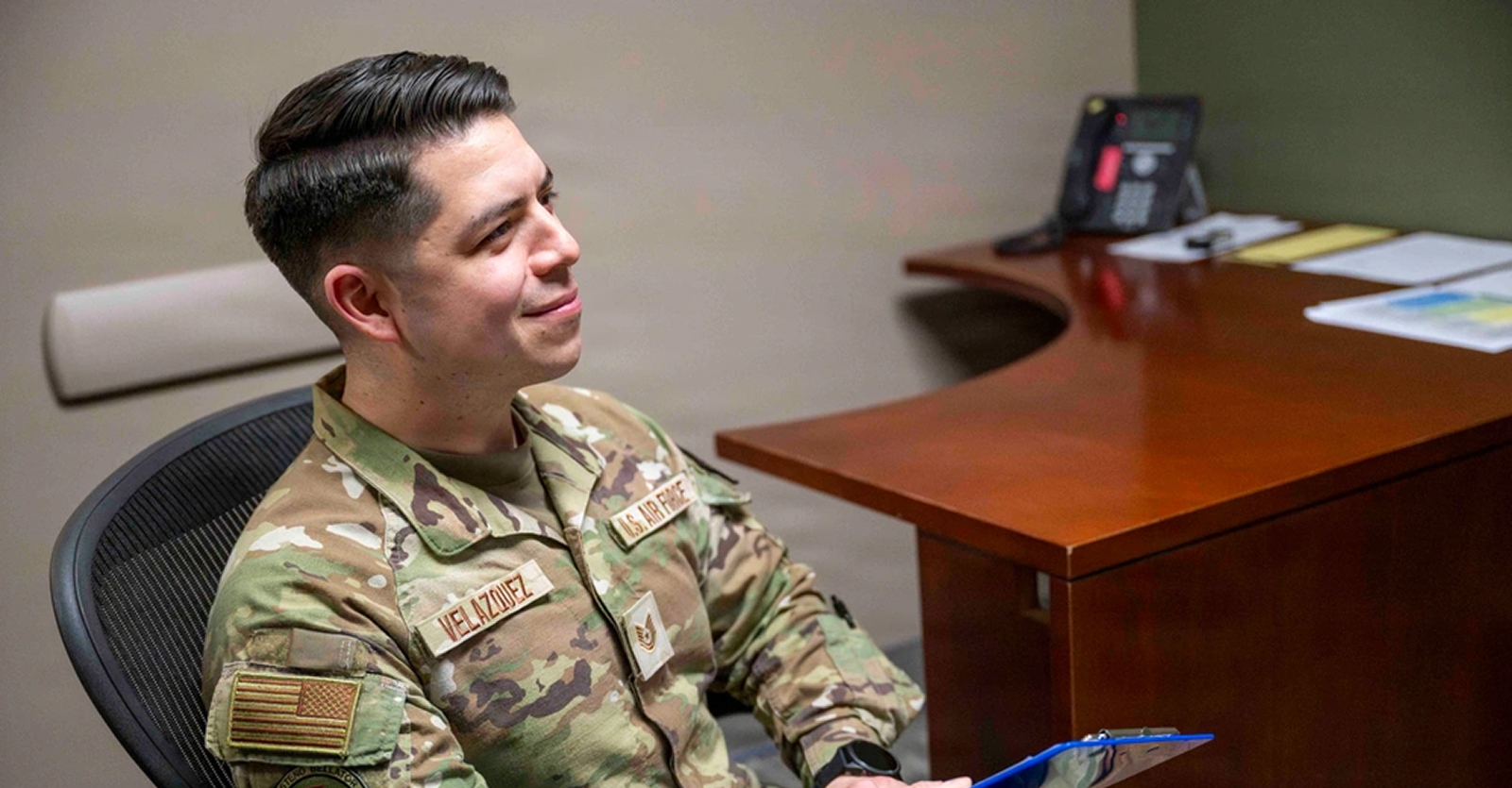 airman smiling at desk