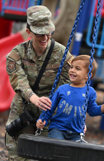 Airman with child on tire swing