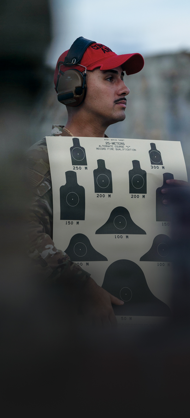 combat arms airman holding target sheet