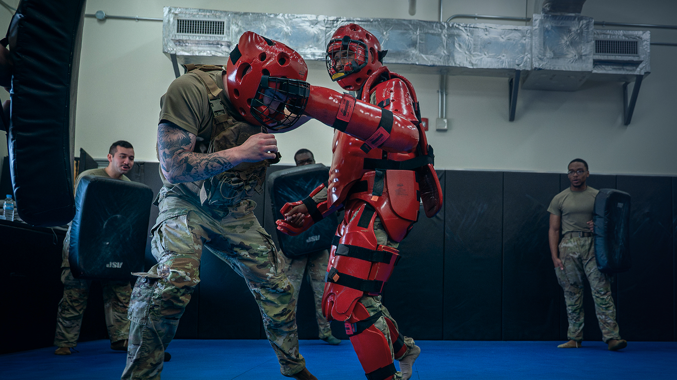 two airmen practicing non-lethal control techniques