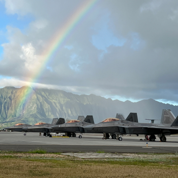 Air National Guard planes on a Hawaiian runway with rainbow and mountains