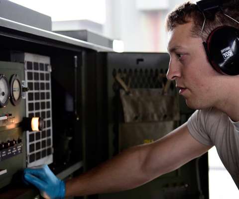 airman wearing headphones calibrating equipment