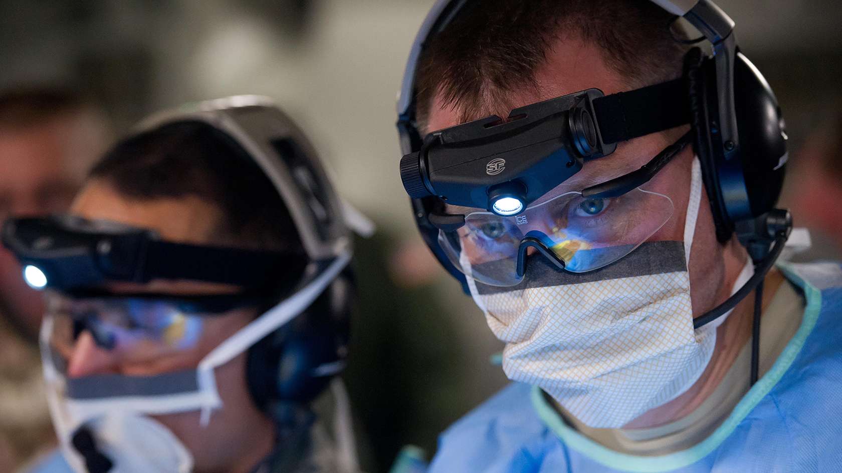 surgeon's face wearing protective eye gear and mask