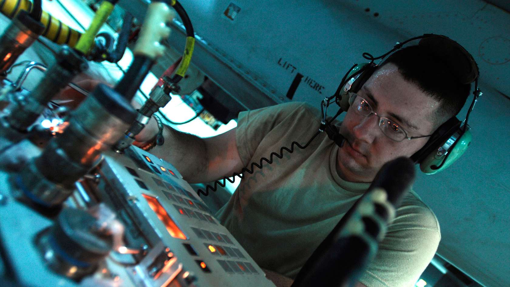 airman wearing headset and looking at control board
