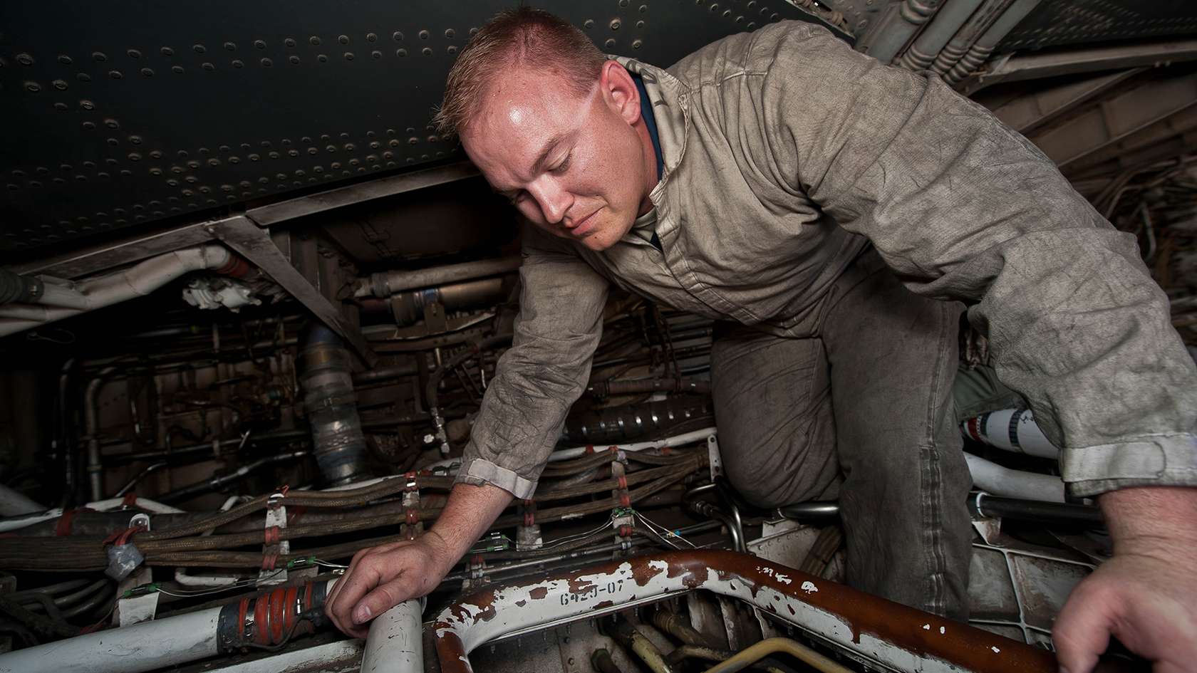 airman performing maintenance on hydraulic systems