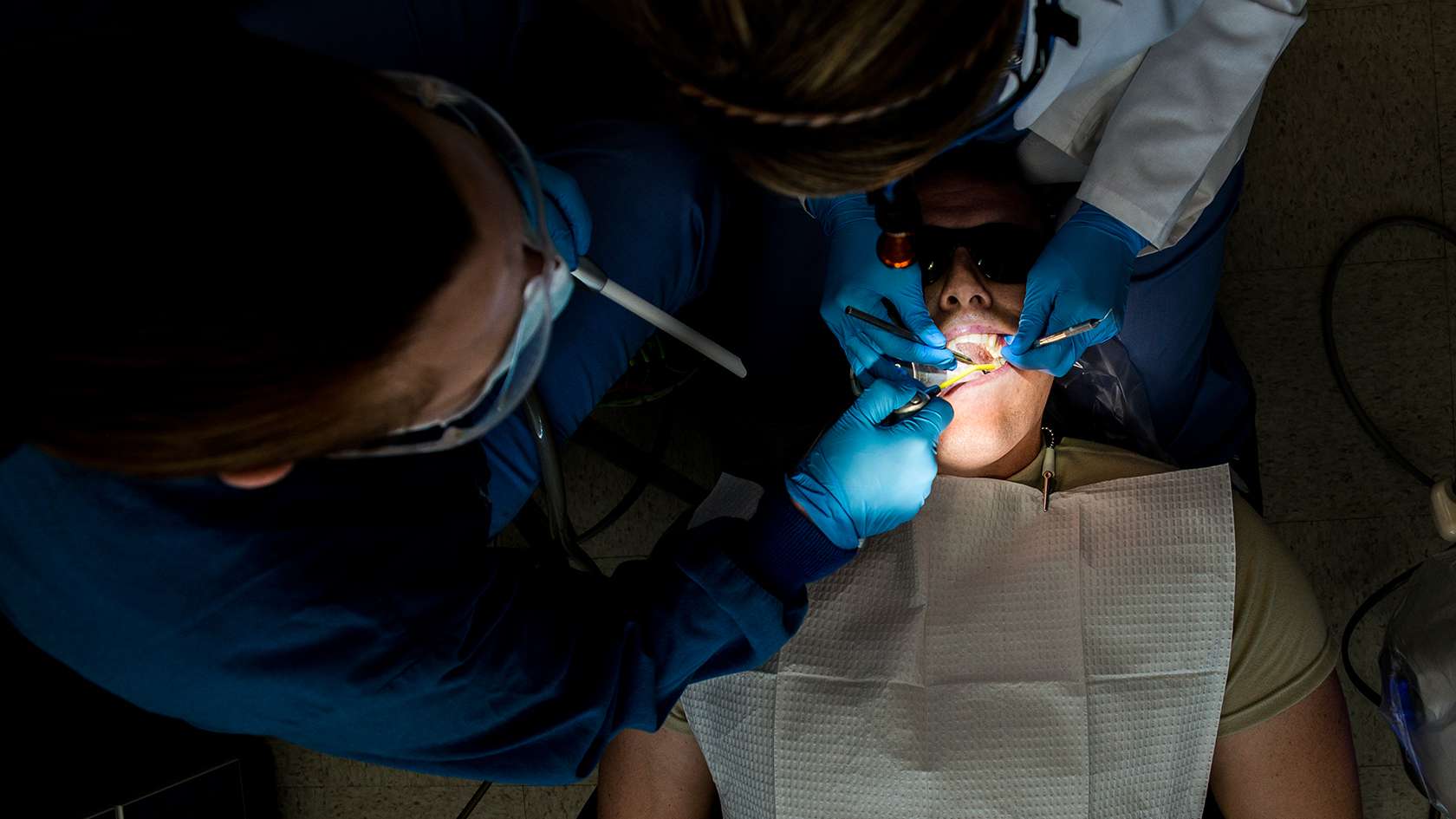 airman cleaning patients teeth
