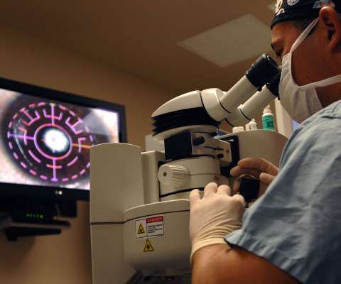 Ophthalmologist looking into eye using device