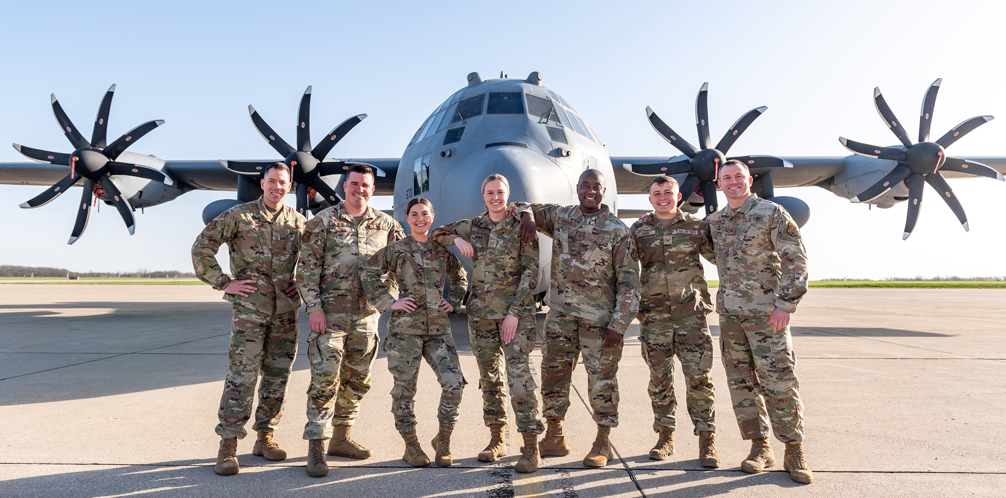 Airmen standing together in front of a plane
