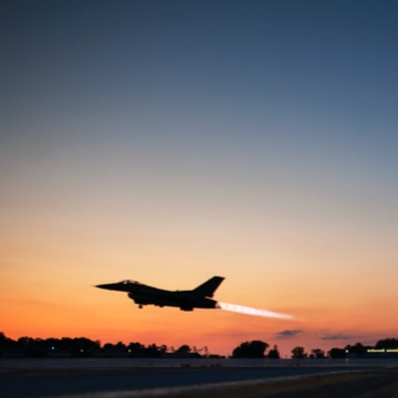 Fighter jet taking off at sunrise