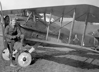 Airman posing with historic aircraft
