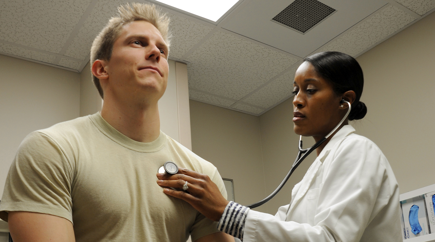 Physician Assistant listening to an airman's heartbeat